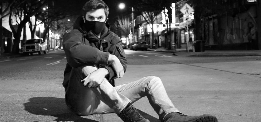 A photograph of Gaelan Lloyd sitting in a deserted street at night